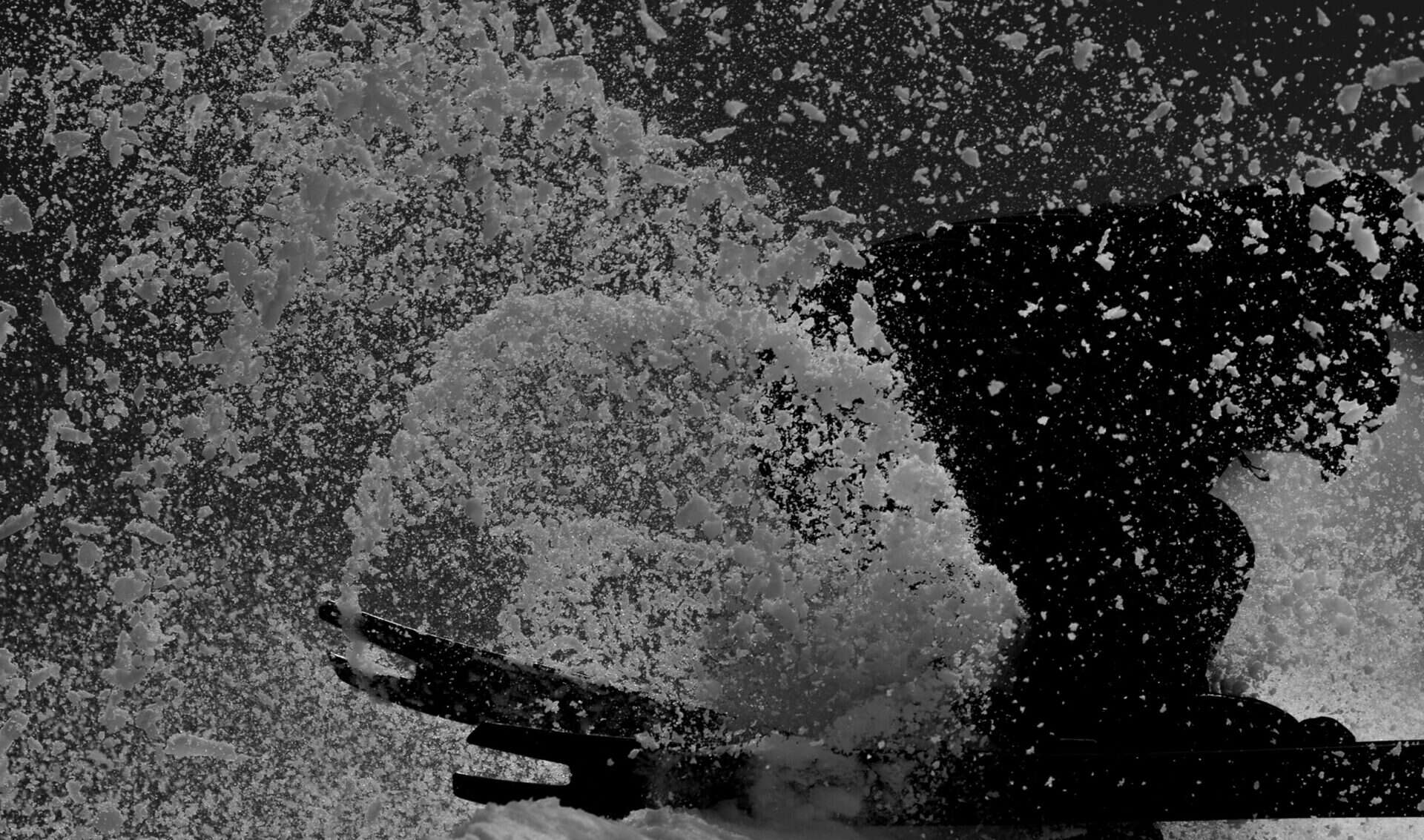 Detail shot of Simply. skis Recreation 180 cutting through deep powder, snow scattering in all directions.