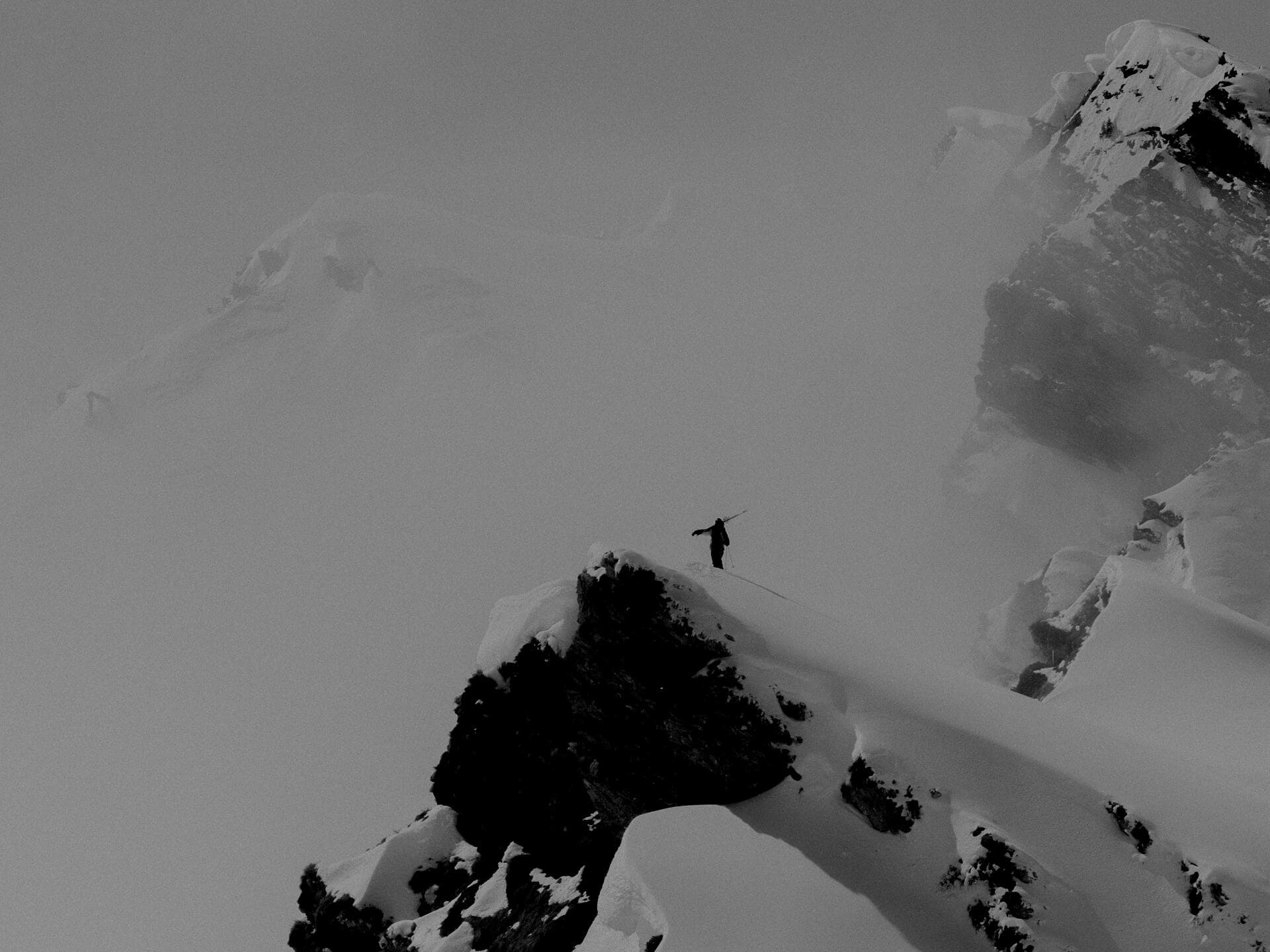 Laurent De Martin approaching cliff drop on big mountain terrain