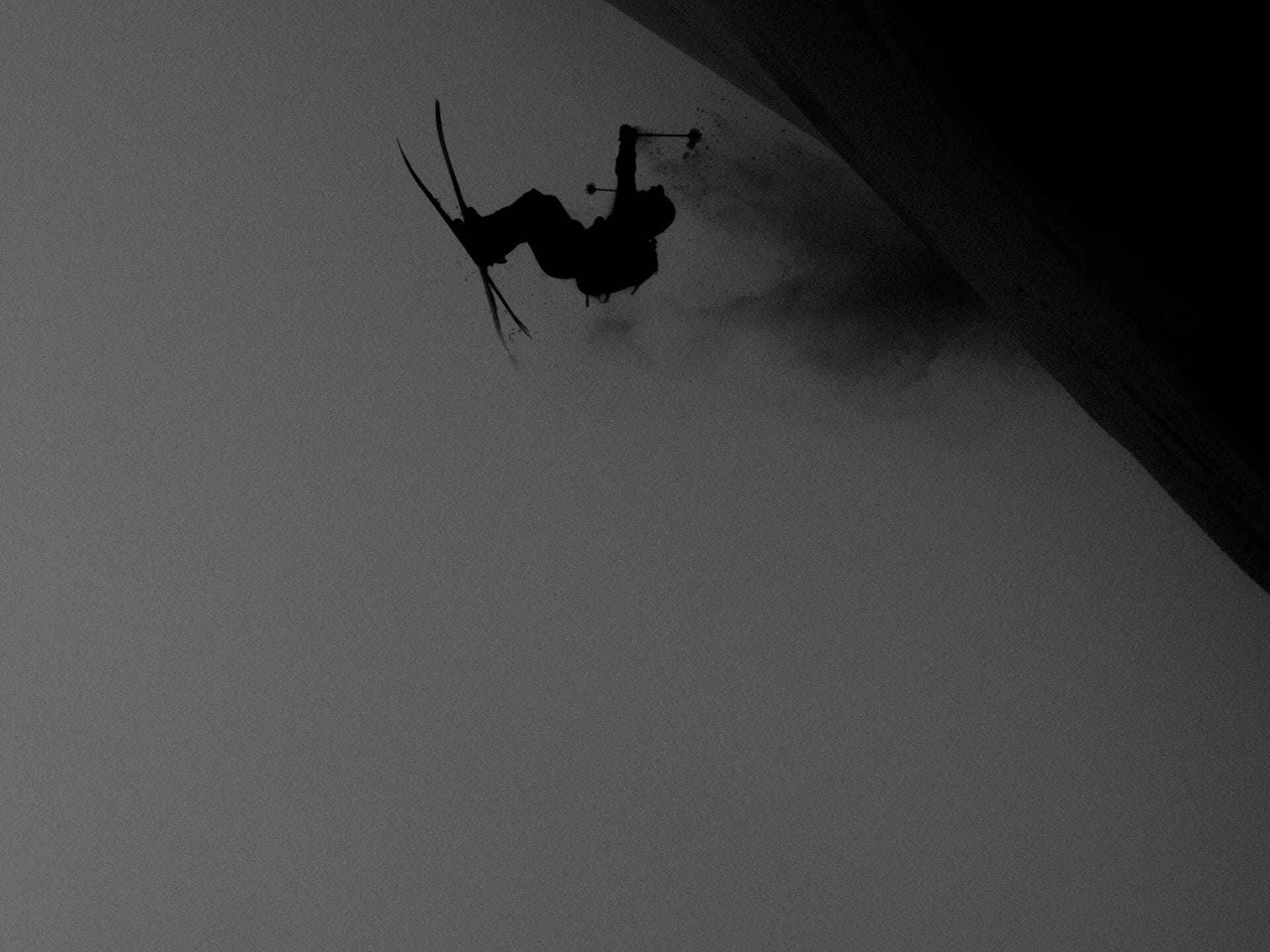Laurent De Martin inverted in freestyle trick against dark sky silhouette